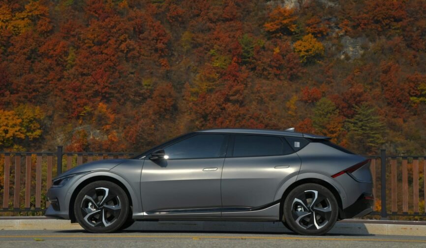 a-silver-car-parked-on-the-side-of-a-road-with-trees-in-the-background-scaled